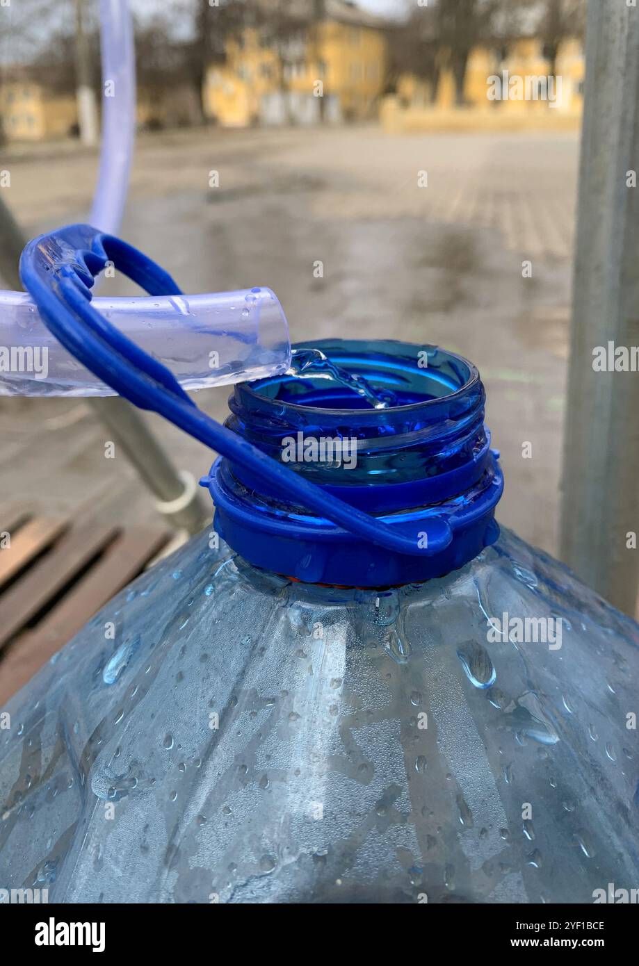 L'invention concerne une bouteille en plastique dans laquelle de l'eau est tirée d'un robinet. Banque D'Images