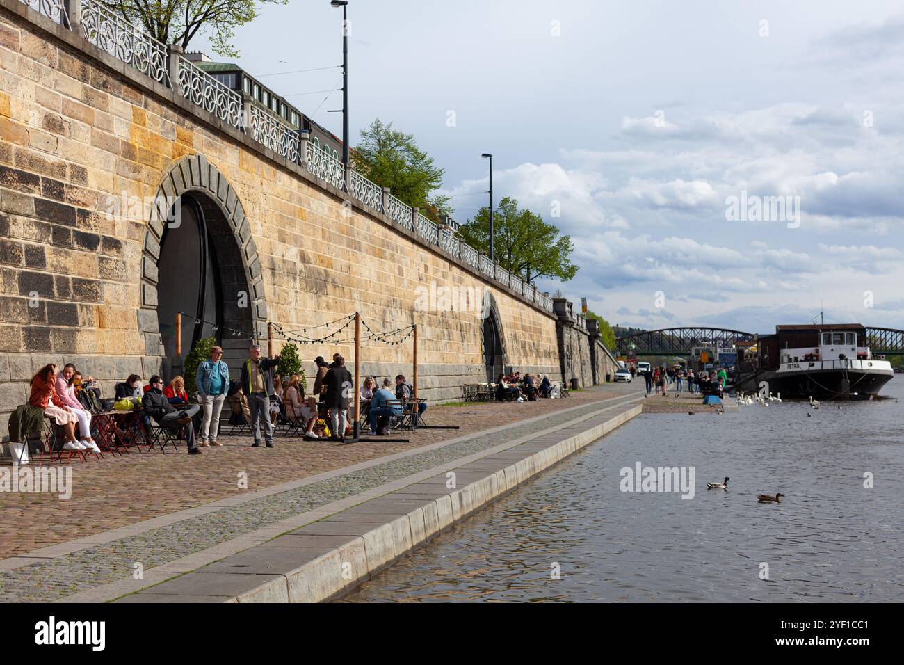 Le front de mer de la rivière Vltava (Náplavka) à Prague avec ses cafés et bars logés dans les voûtes du mur du remblai, République tchèque. Banque D'Images