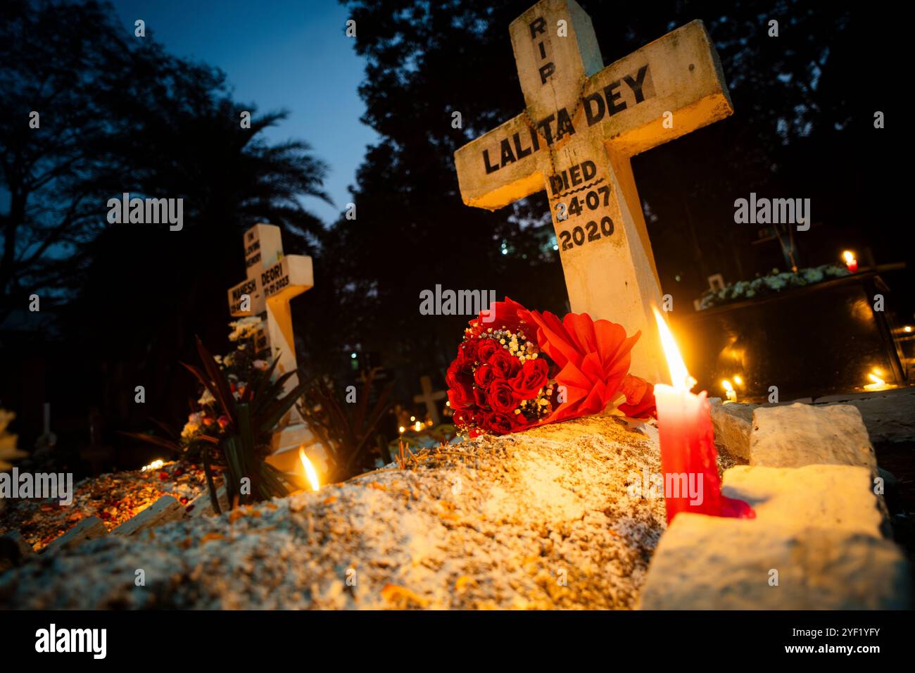 Des gens de la communauté chrétienne allument des bougies et offrent des prières sur la tombe de leur parent lors de l'observation de la journée de toutes les âmes, à Guwahati, en Inde, le 2 novembre 2024. All Souls' Day est une fête chrétienne dédiée à honorer et prier pour les âmes des défunts. Crédit : David Talukdar/Alamy Live News Banque D'Images