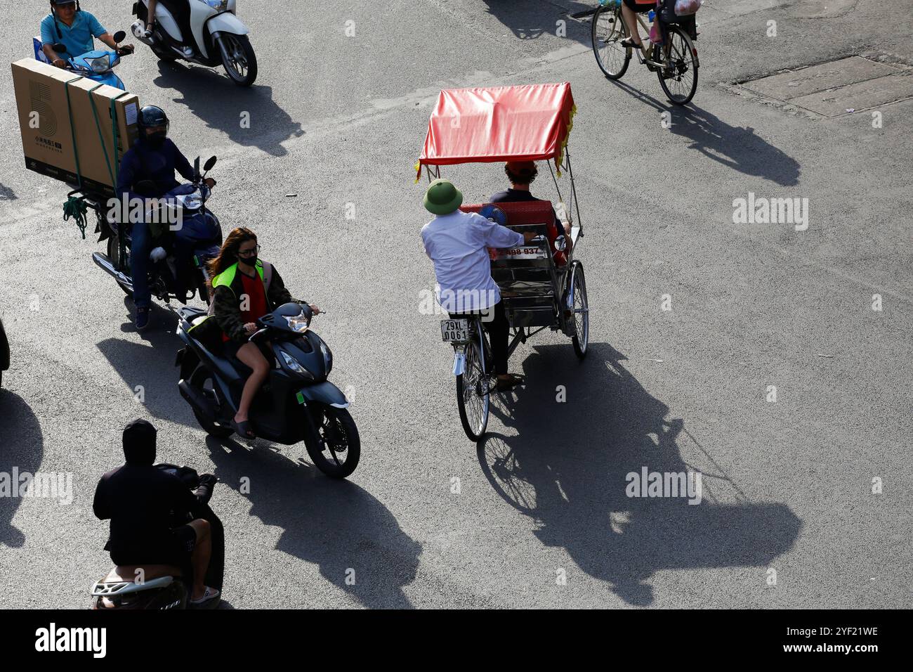 Hanoi, Vietnam - 10 juillet 2023 : vue aérienne de motocyclistes et d'un conducteur de tuk tuk traversant la place Dong Kinh Nghia Thuc. Banque D'Images