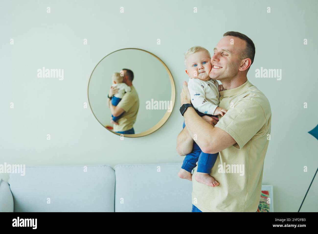 Le jeune papa souriant joue avec son fils nouveau-né. Papa et petit fils. Banque D'Images