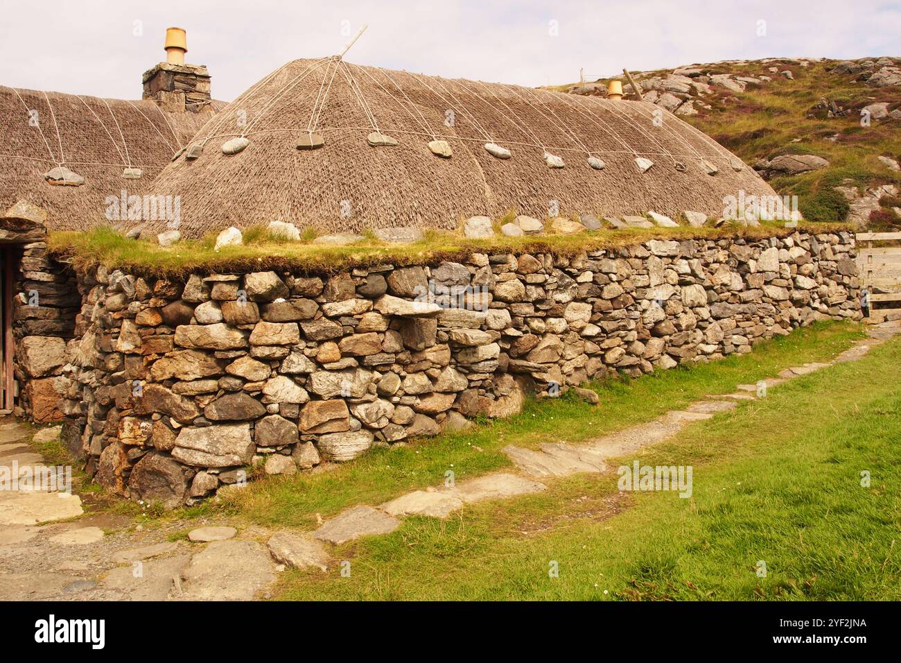 Le village de maison noire à Gearrannan sur l'île de Lewis, en Écosse. UK montrant les murs en pierre solide et les toits de chaume des habitations Banque D'Images