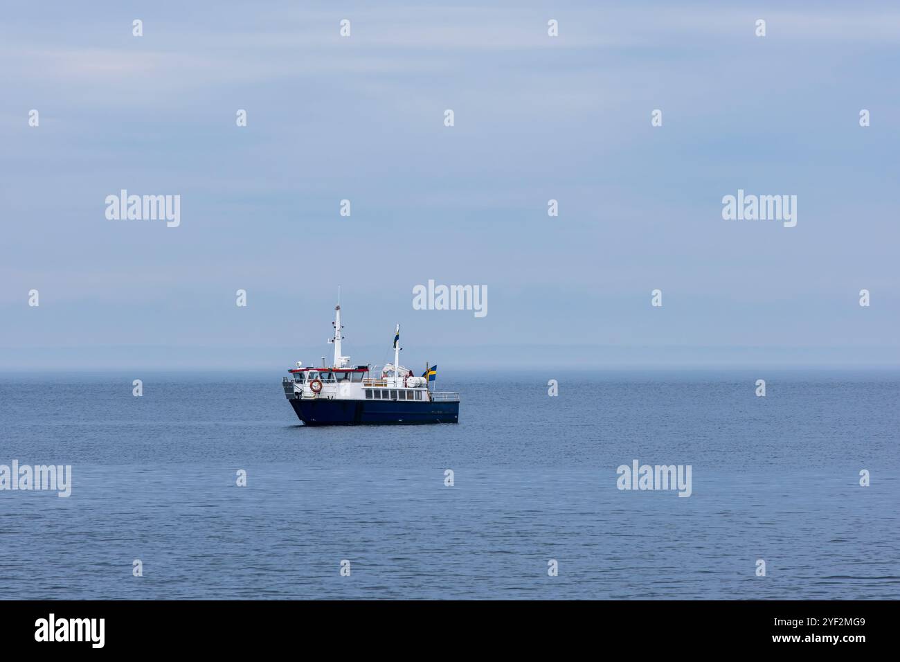 Un bateau d'excursion est amarré au large de la côte de la jeune fille bleue (Bla Jungfrun), une île et un parc national dans le nord du détroit de Kalmar, en Suède. Banque D'Images