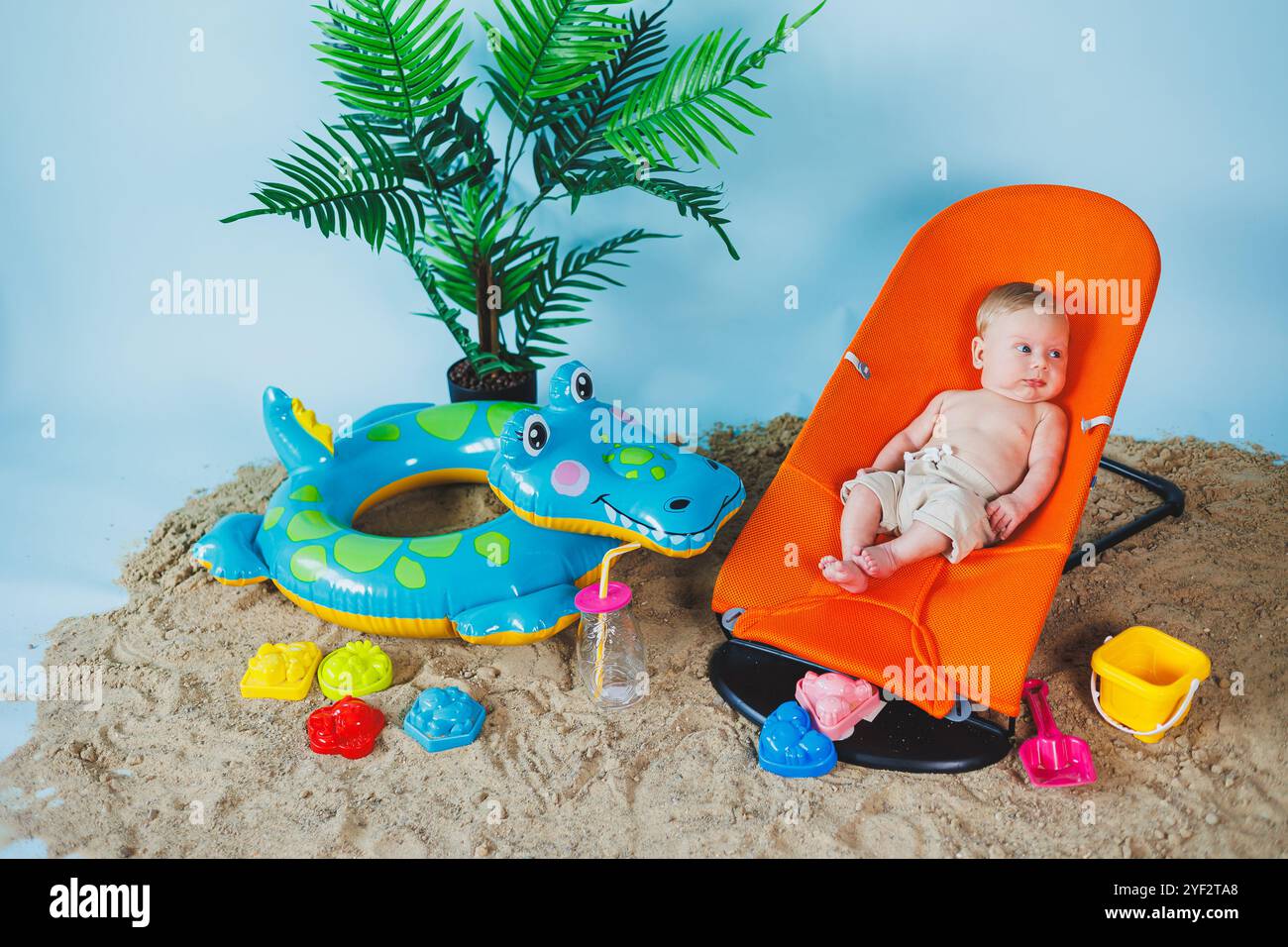 Un bébé est allongé sur un fauteuil inclinable pour bébés. Loisirs pour enfants. Banque D'Images