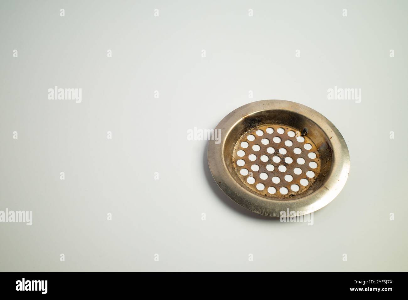 Couvercle de drain métallique avec perforations circulaires sur une surface propre Banque D'Images