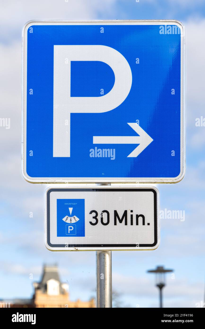 Un panneau de stationnement bleu indiquant une limite de stationnement de 30 minutes avec une flèche pointant vers la droite. Ce panneau de rue allemand met en évidence les zones de stationnement à durée limitée Banque D'Images