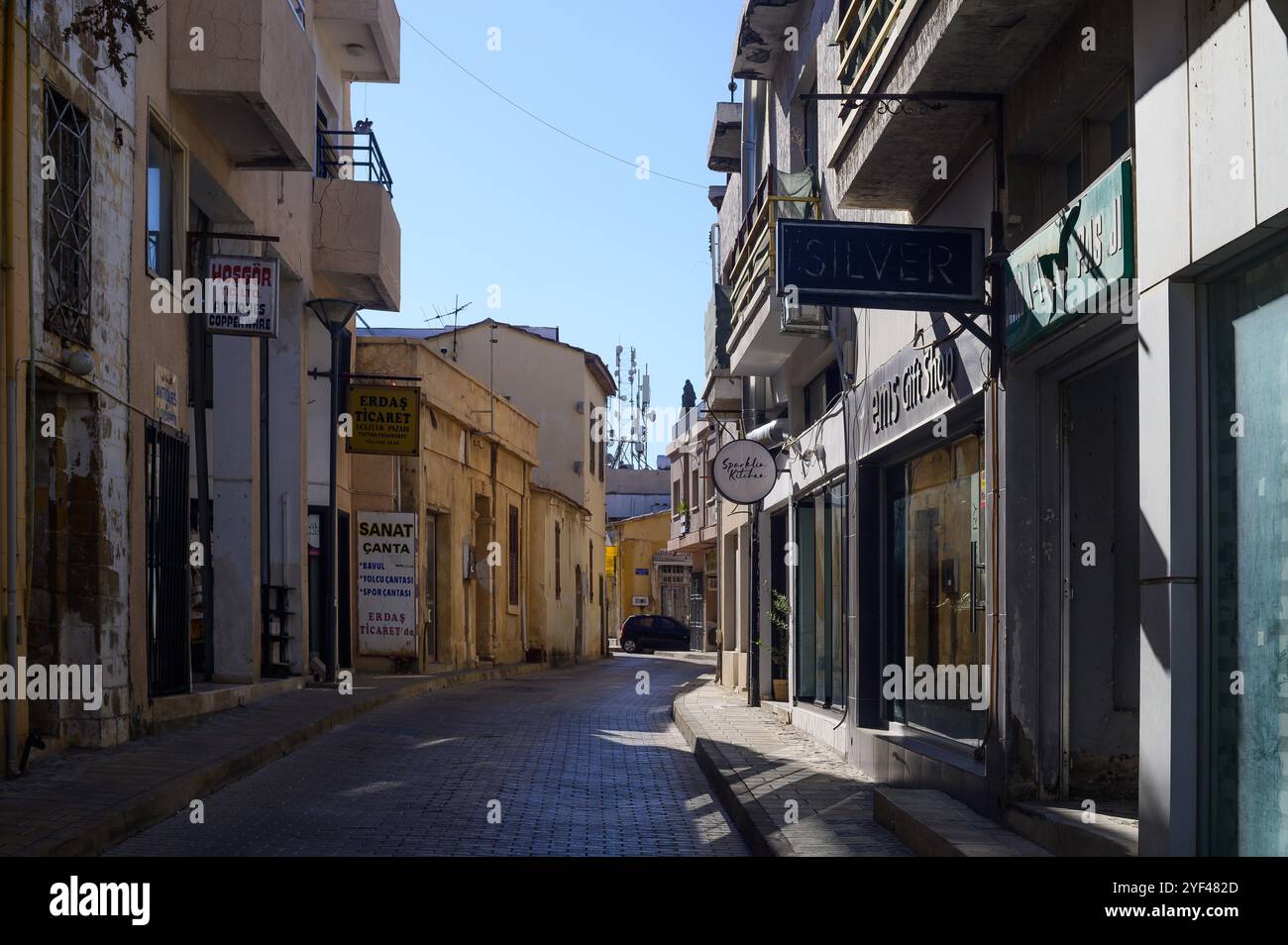 Une ravissante ruelle étroite bordée de boutiques uniques et de lumière chaude du soleil illuminant l'atmosphère tranquille de la vieille ville. Banque D'Images