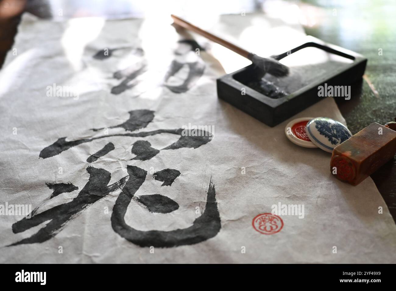 Calligraphie asiatique orientale avec pinceau, encre et papier de riz et tampon de nom. Banque D'Images