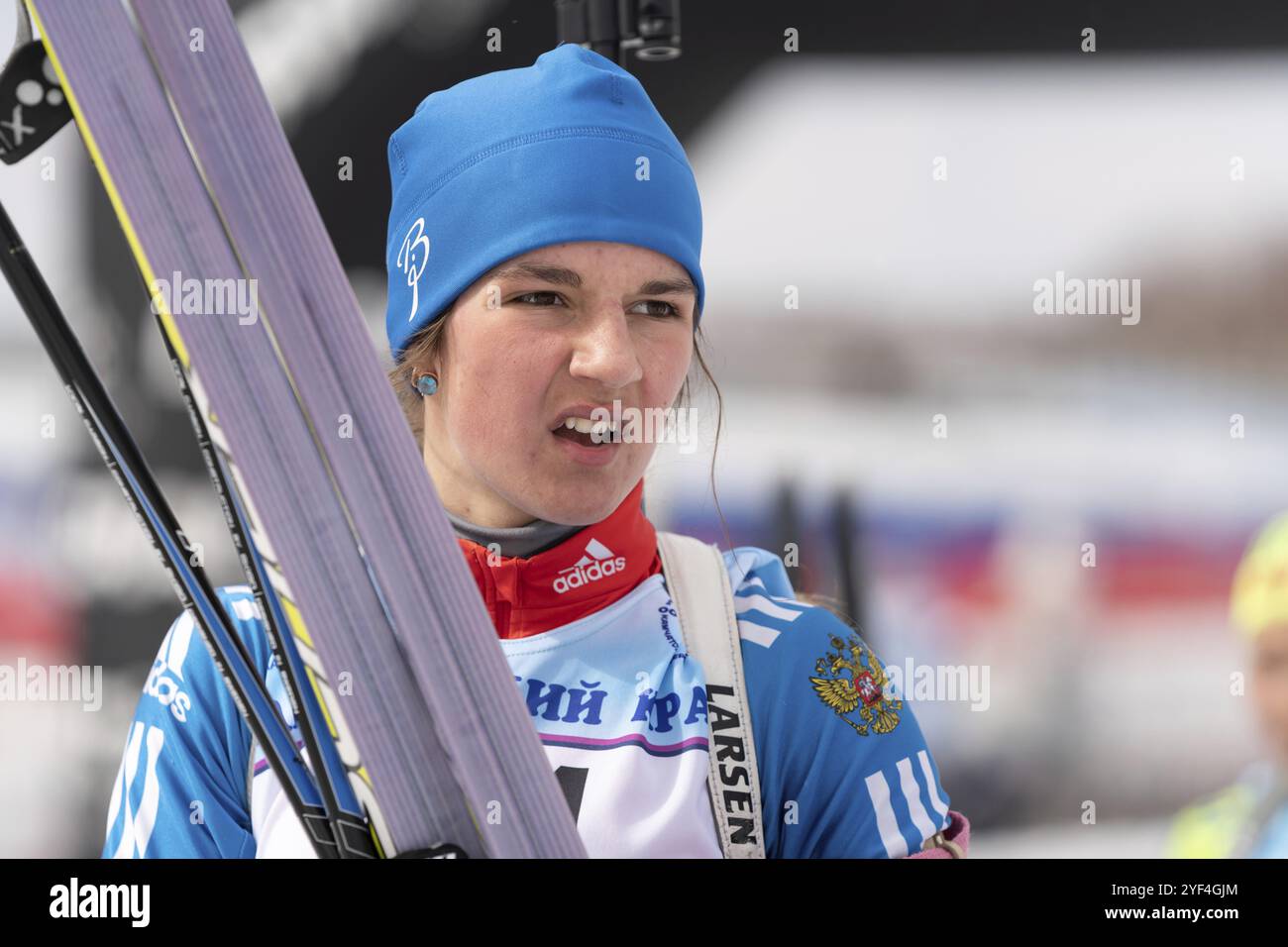 La biathlète sportive Soenko Violetta avec des skis dans les mains et un fusil derrière elle après le ski et le tir à la carabine. Compétition régionale ouverte de biathlon jeunesse Banque D'Images