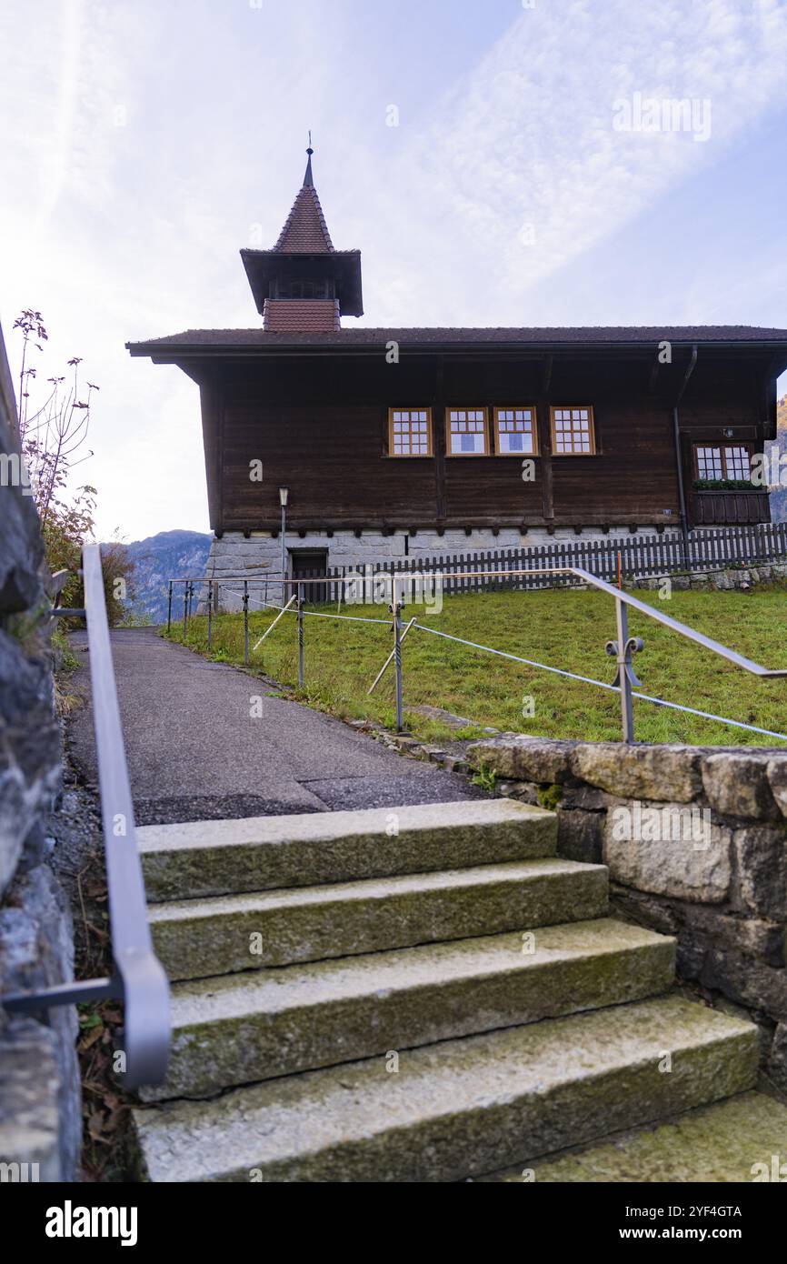 Maison traditionnelle en bois sur une colline avec escaliers et balustrades au premier plan, Lauterbrunnen, Suisse, Europe Banque D'Images