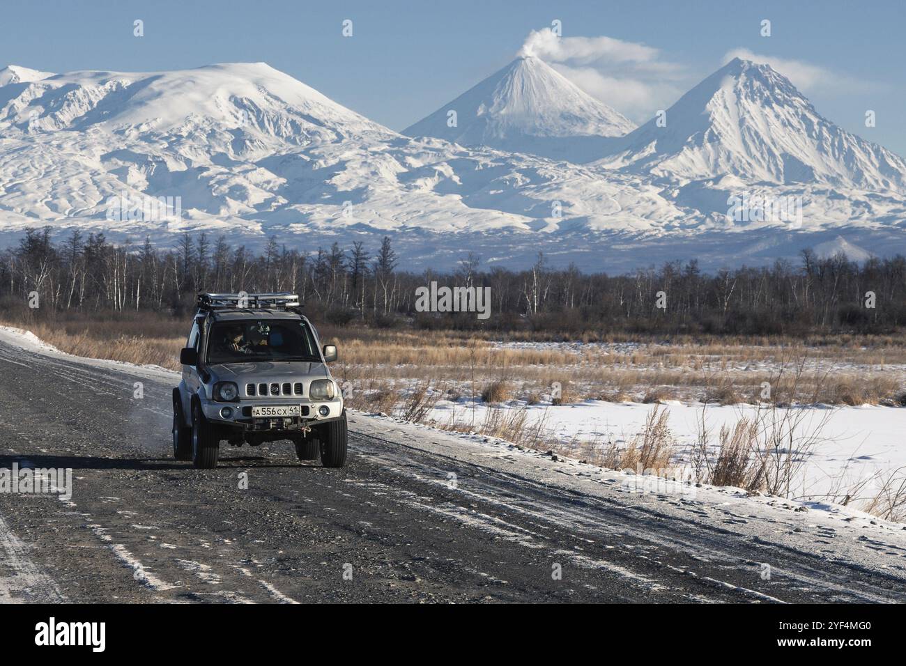 Véhicule utilitaire sport japonais Suzuki Jimny conduisant le long de la route sur fond de belles destinations de voyage de paysage d'hiver, actif Kluchevskoy volcan Banque D'Images