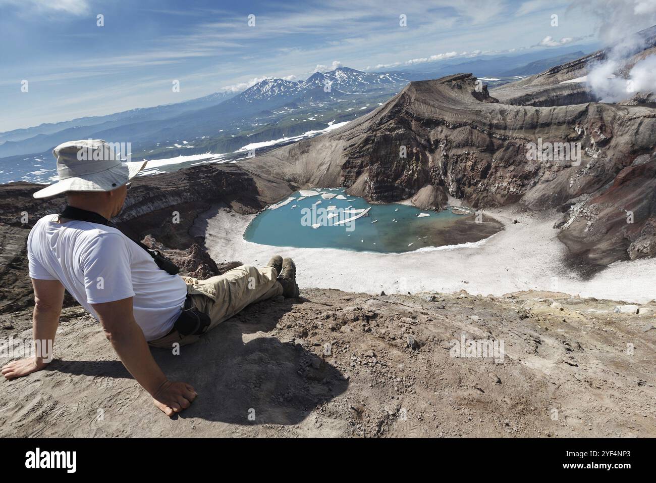 VOLCAN GORELY, PÉNINSULE DU KAMTCHATKA, EXTRÊME-ORIENT RUSSE, 21 JUILLET 2013 : les touristes s'assoit au sommet du cratère du volcan Gorely actif et se détend à regarder Banque D'Images