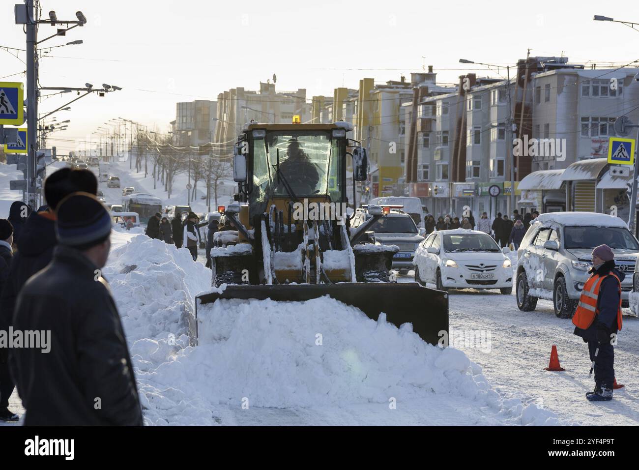PETROPAVLOVSK KAMTCHATSKY CITY, KAMTCHATKA PENINSULA, RUSSIAN FAR EAST, DEC 27, 2017 : chargeuse sur pneus avant nettoie après la tempête de neige hivernale (blizzards) m Banque D'Images