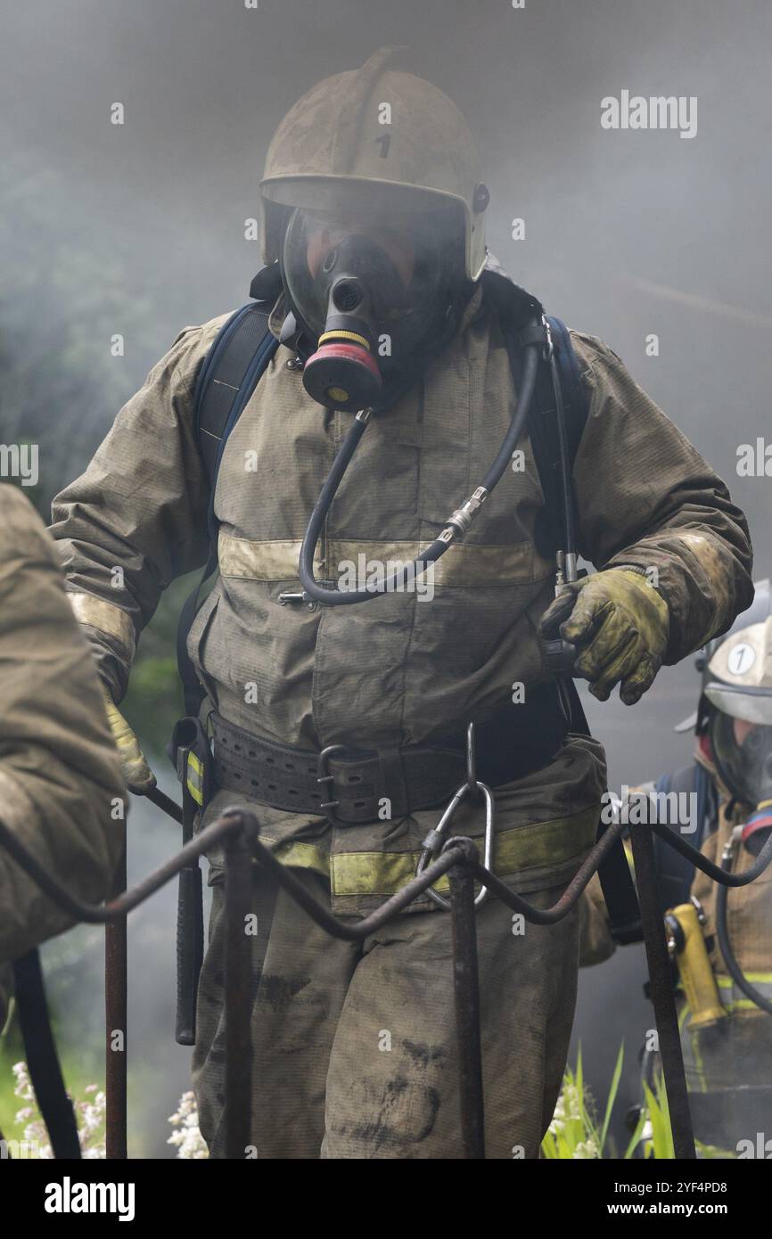 Les pompiers du service des incendies Service Incendie fédéral au cours de la formation, d'extinction d'incendie pour surmonter une zone de feu de formation psychologique pour firefight Banque D'Images