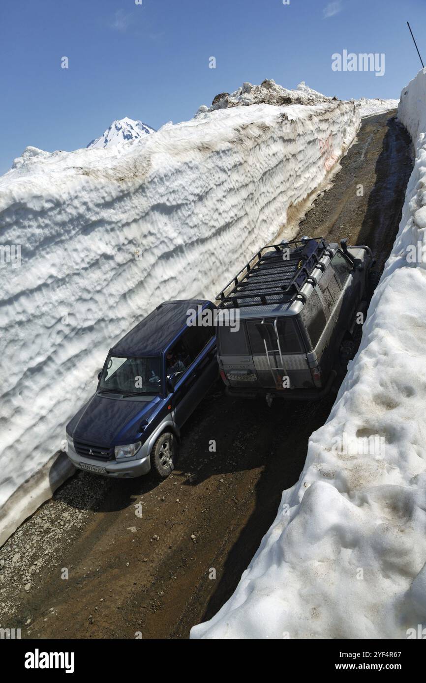 PÉNINSULE DU KAMCHATKA, RUSSIE, 18 JUIN 2017 : voitures hors route japonaises Toyota Land Cruiser Prado et Mitsubishi Pajero Io conduisant sur route de montagne dans la neige Banque D'Images