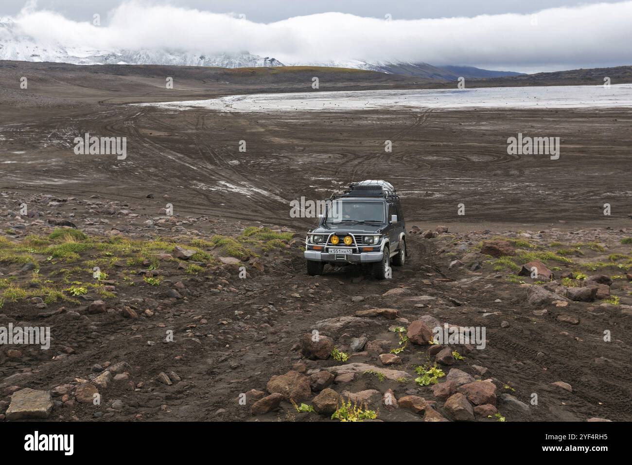 KAMCHATKA PENINSULA, RUSSIE, 17 SEPTEMBRE 2016 : voiture d'expédition hors route extrême Toyota Land Cruiser Prado conduisant sur la route de montagne sur fond de v Banque D'Images