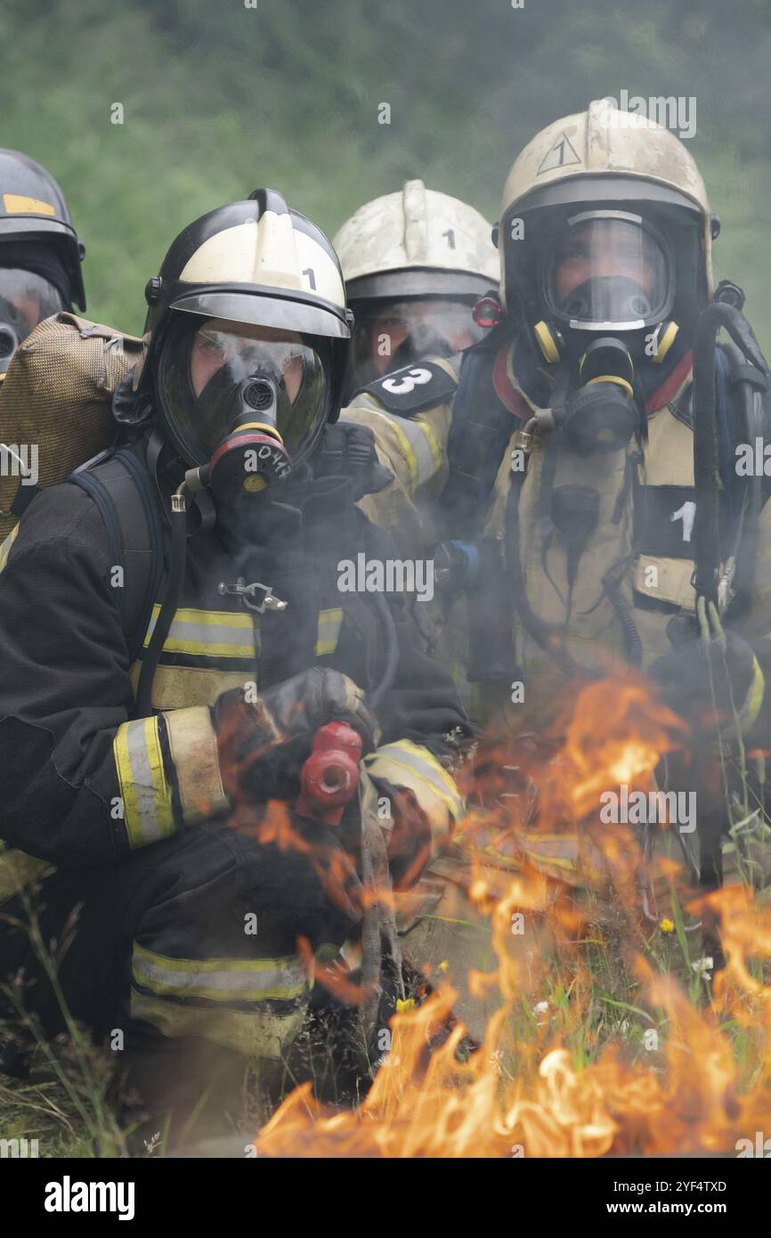 Les pompiers du service des incendies Service Incendie fédéral au cours de la formation, d'extinction d'incendie pour surmonter une zone de feu de formation psychologique pour firefight Banque D'Images