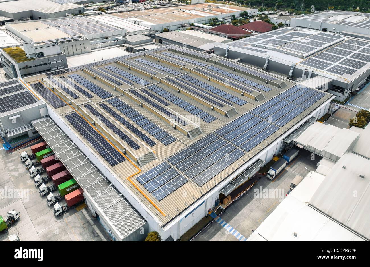 Entrepôt à énergie solaire avec camions de fret aux quais de chargement. Logistique écologique et transport de marchandises efficace. Panneaux solaires Banque D'Images