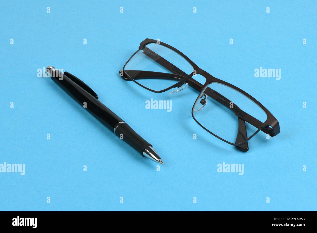 Stylo à bille noir Business avec lunettes de lecture isolé sur fond bleu. Concept de bureau et de secrétariat. Photo haute résolution. Profondeur totale de fi Banque D'Images