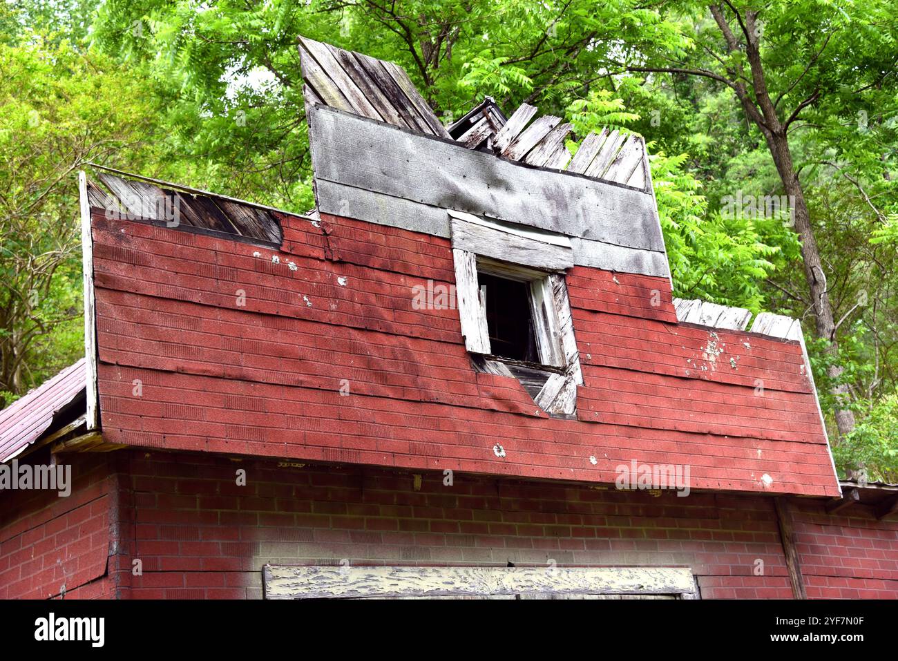 La façade de l'ancien magasin a un dos en bois avec revêtement en amiante rouge. Le bois est en pourriture et le bardage est manquant. Banque D'Images