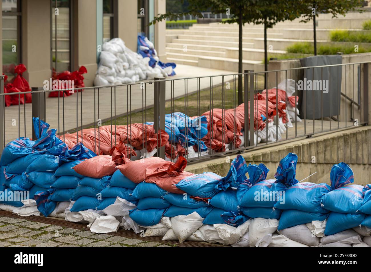 Les sacs de sable rouges, bleus et blancs créent une structure de défense temporaire pour éviter les dégâts d'eau Banque D'Images