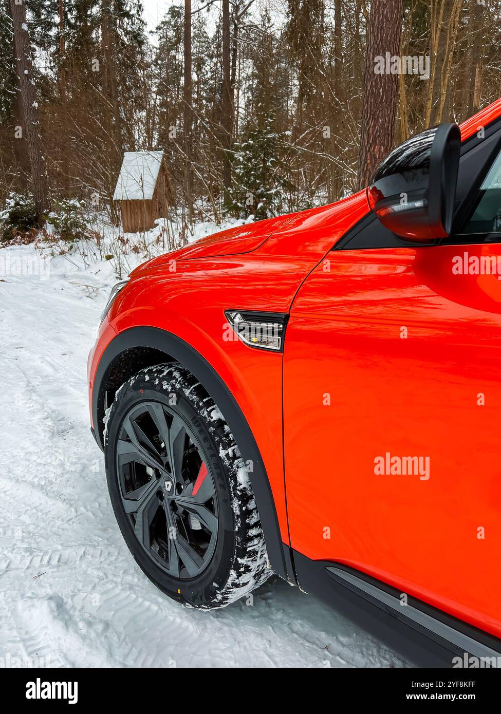 Riga, Lettonie - 25 janvier 2023 : Renault Arkana RS-line Valencia Orange une voiture hybride compacte multisegment E-tech en hiver. Fabricant automobile français Banque D'Images