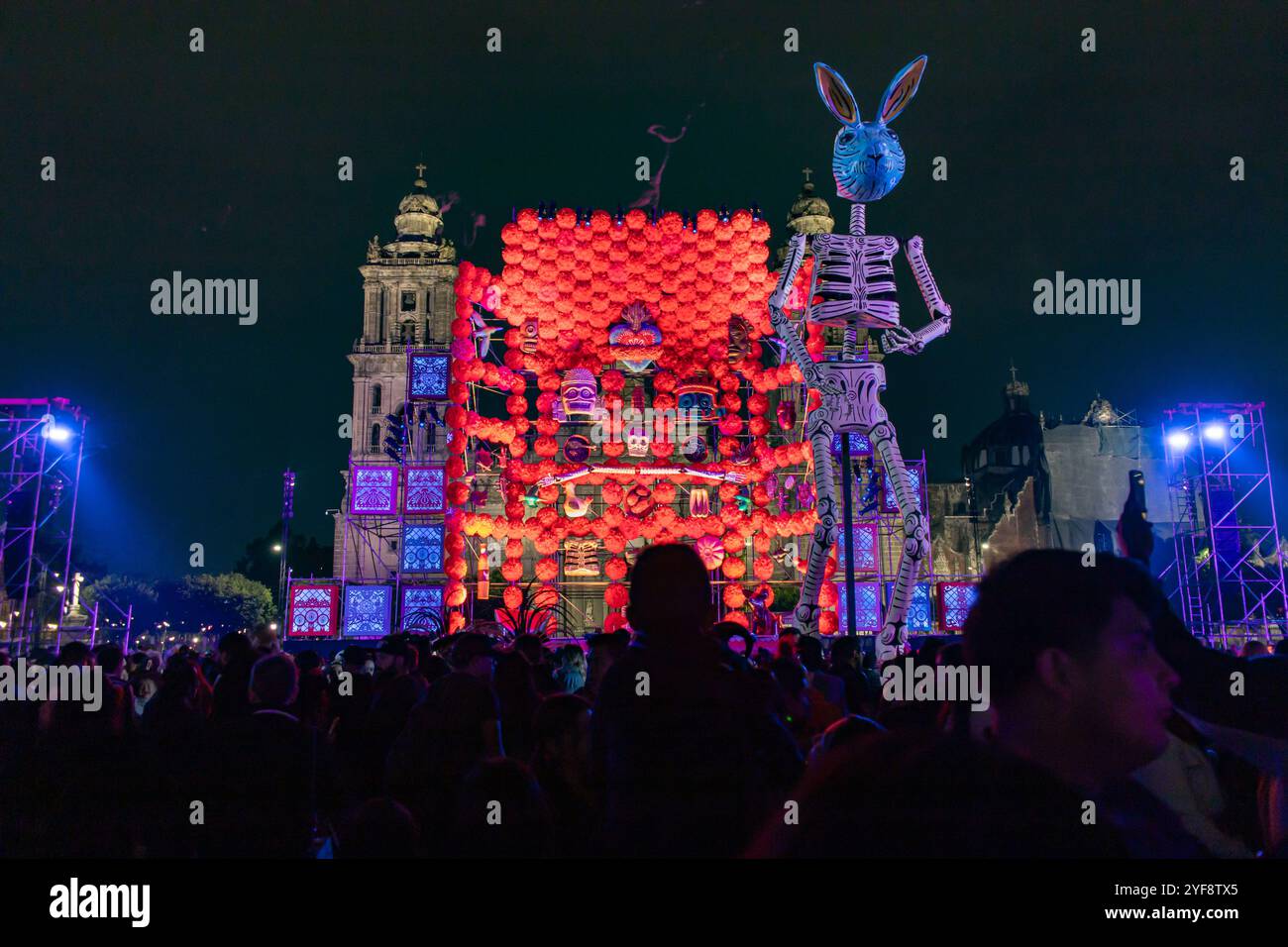 Un jour vibrant de l'autel mort avec des décorations illuminées et des squelettes illumine Zócalo la nuit, Mexico. Dia de Muertos. Banque D'Images