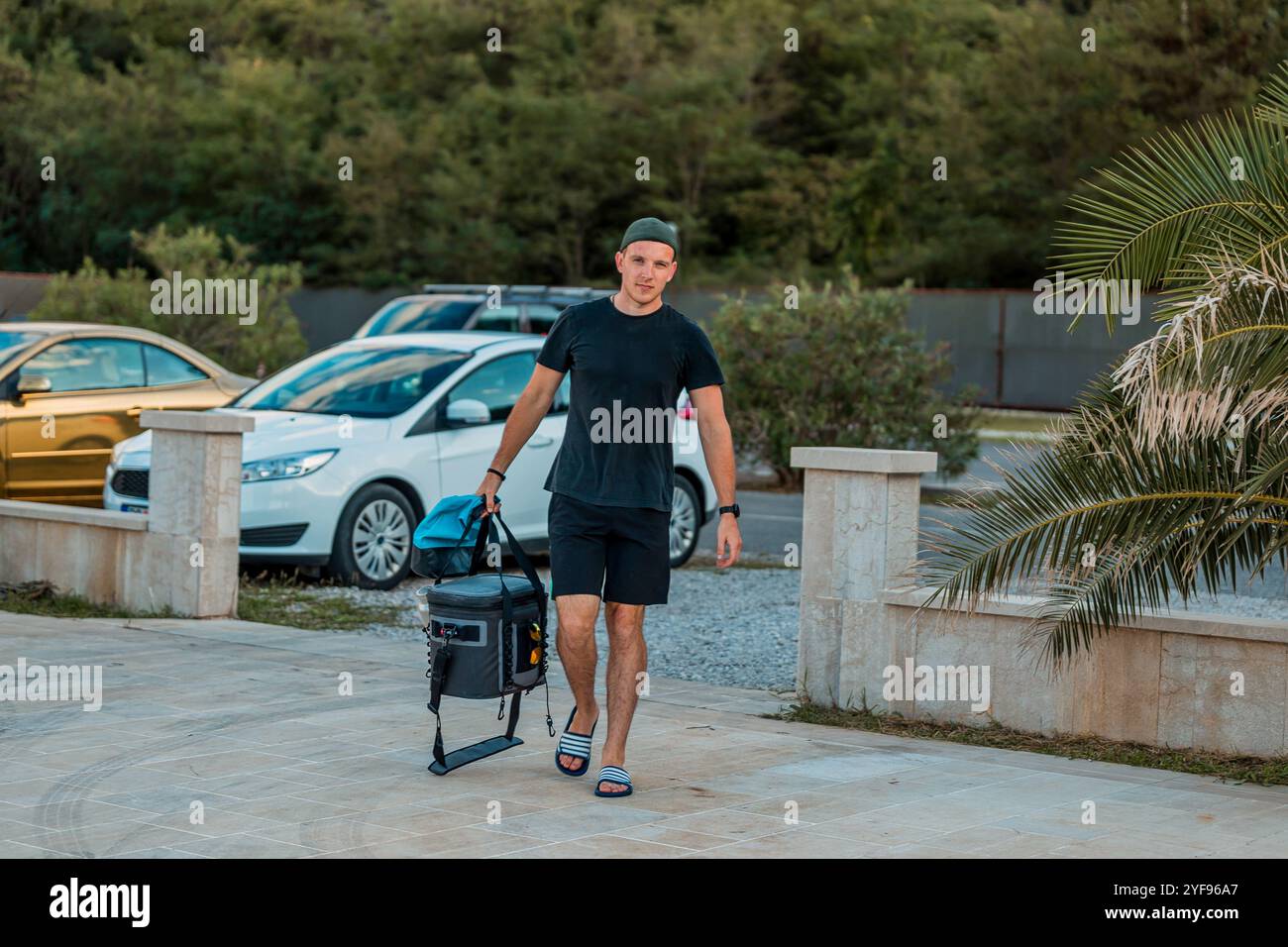 homme actif avec équipement de paddleboard marchant vers la plage pour une journée d'aventure de sports nautiques Banque D'Images
