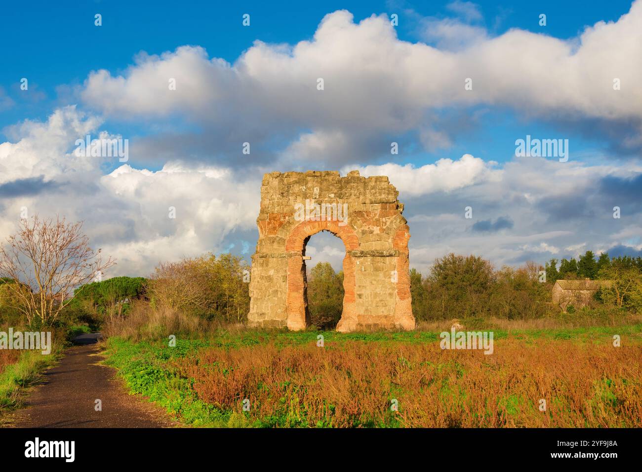 Ancien aqueduc romain de belles ruines d'arches dans le parc public de Rome avec de beaux nuages Banque D'Images