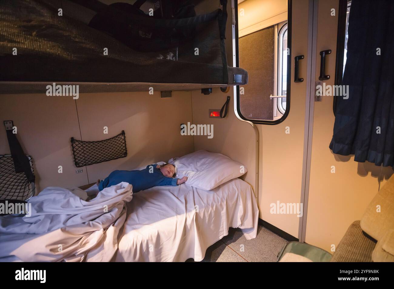 Garçon en bas âge dormant sur le lit dans le train-couchette Banque D'Images