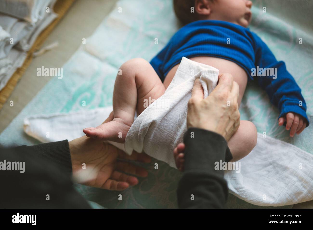 Directement au-dessus de la vue de la femme âgée changeant la couche d'un nouveau-né couché à la maison Banque D'Images