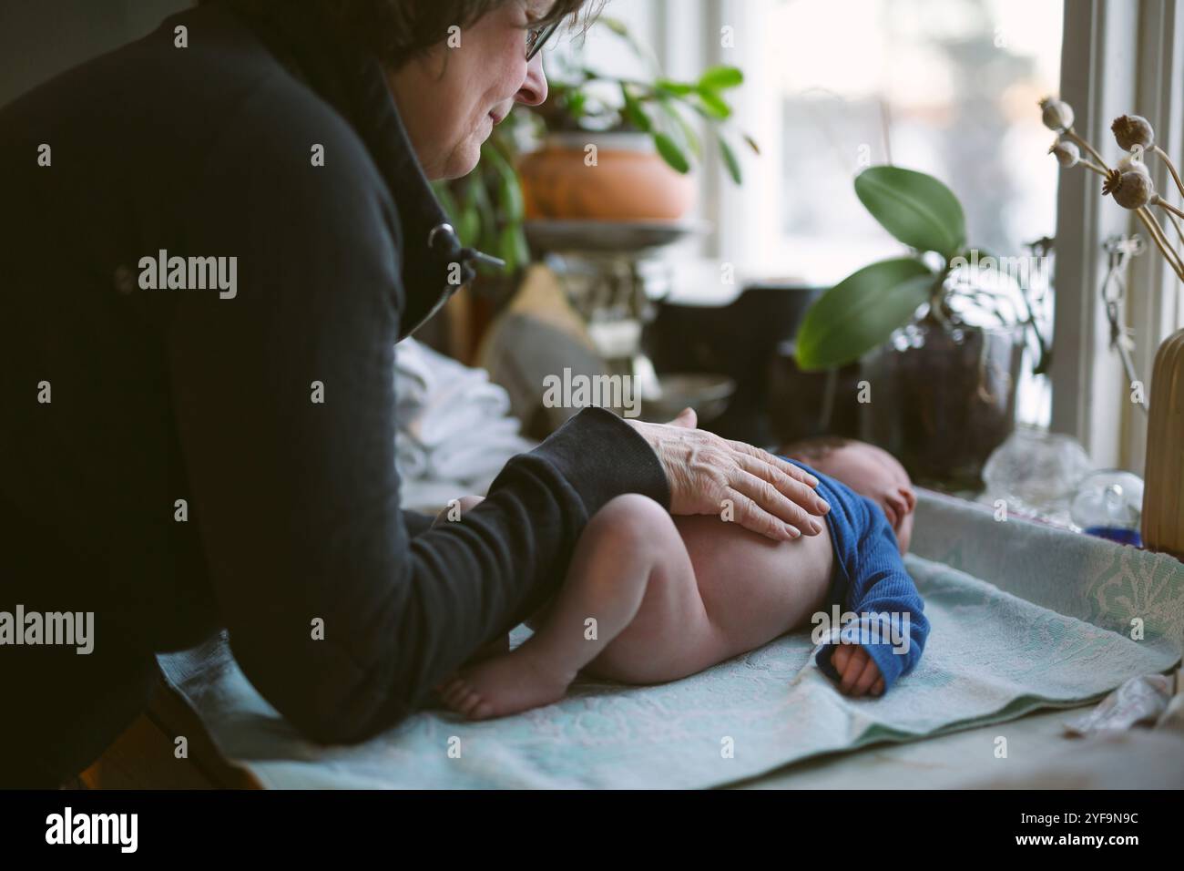Grand-mère prenant soin de son petit-fils allongé à la maison Banque D'Images