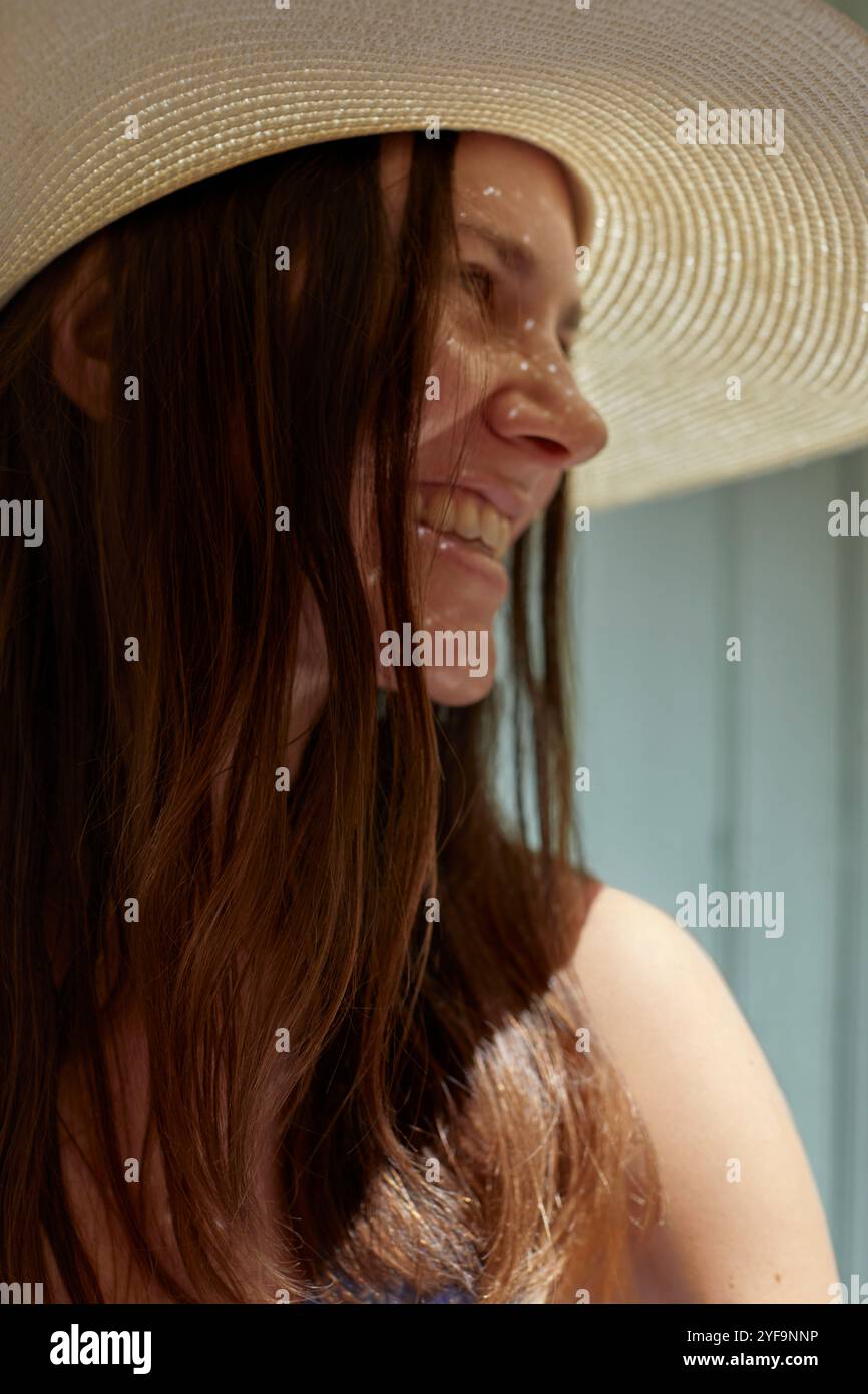 Gros plan d'une femme souriante portant un chapeau de paille Banque D'Images