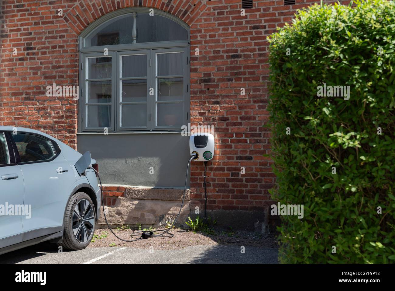 Voiture électrique en cours de charge à l'extérieur du bâtiment Banque D'Images