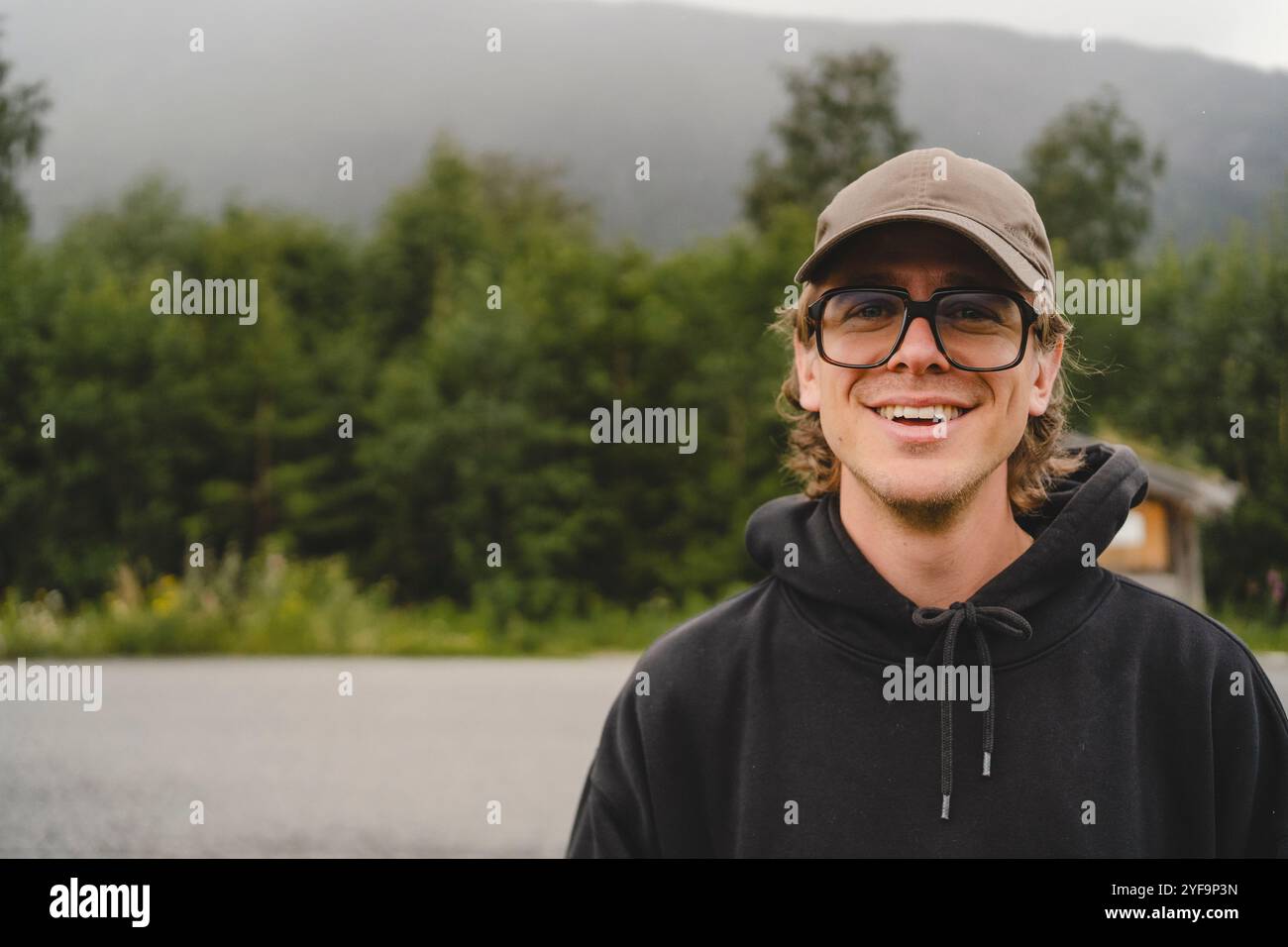 Portrait d'un jeune homme souriant par la route Banque D'Images