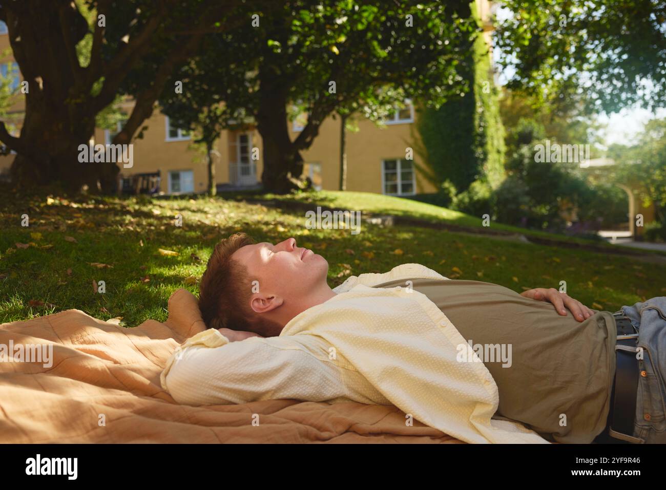 Jeunes hommes sieste sur tapis dans un parc public Banque D'Images