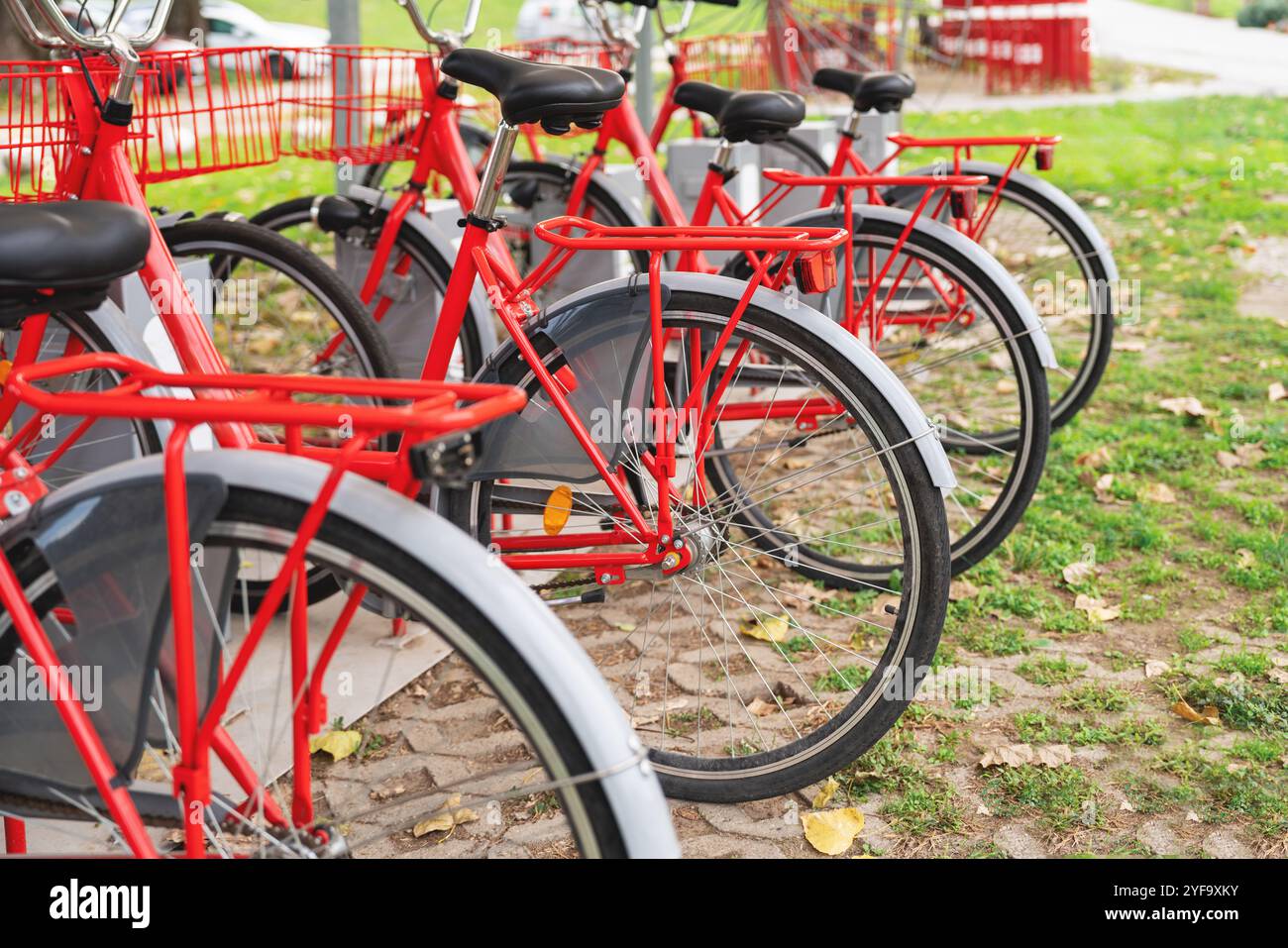 Vélos de location Red City alignés en rangée à l'extérieur, prêts pour les navetteurs urbains. Station de partage de vélos Banque D'Images