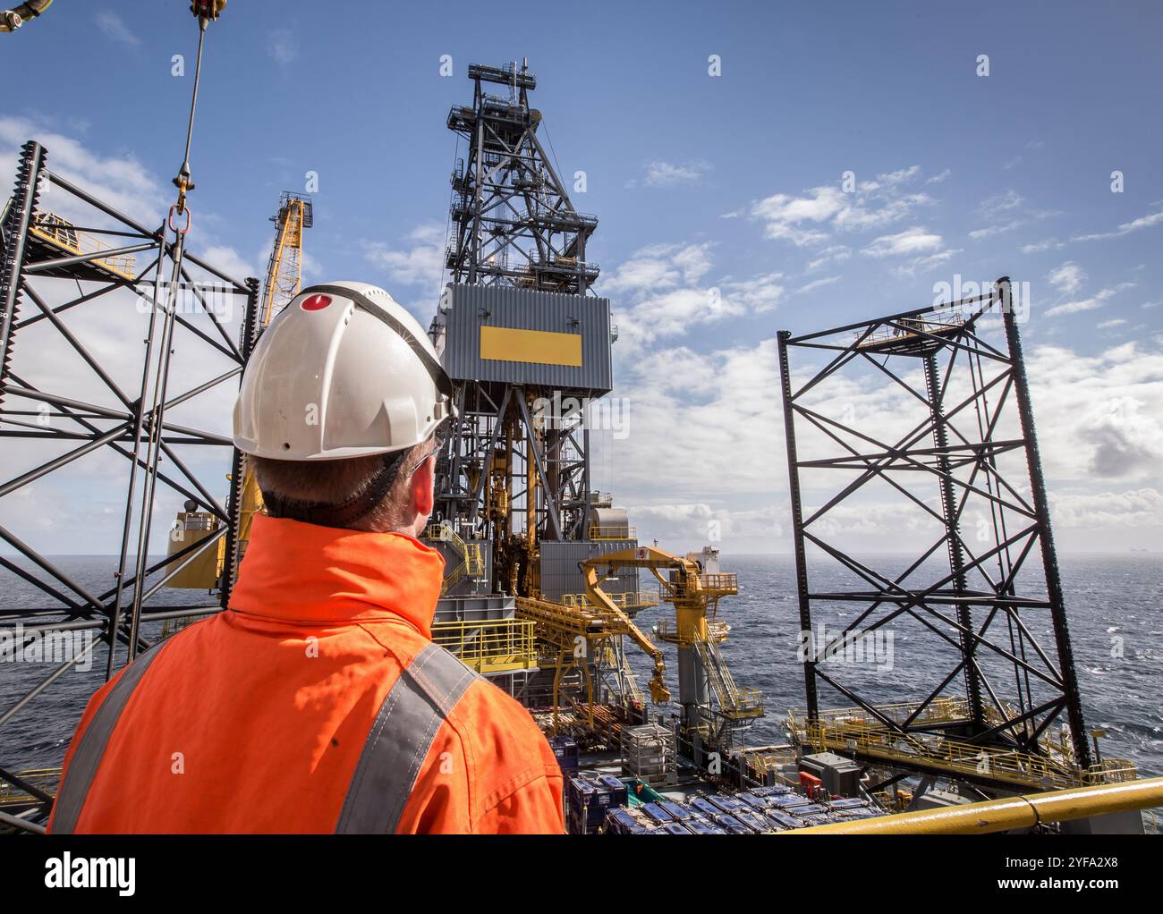 Ouvrier pétrolier sur un engin de forage à cric Banque D'Images