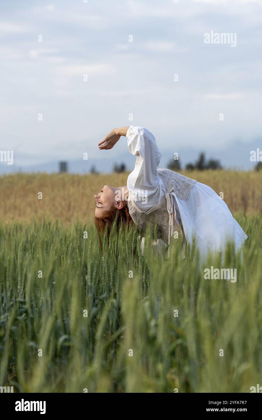 Jeune danseuse dansant à l'extérieur. Performance de danse moderne dans le champ de prairie. Insouciance et liberté dans la nature Banque D'Images