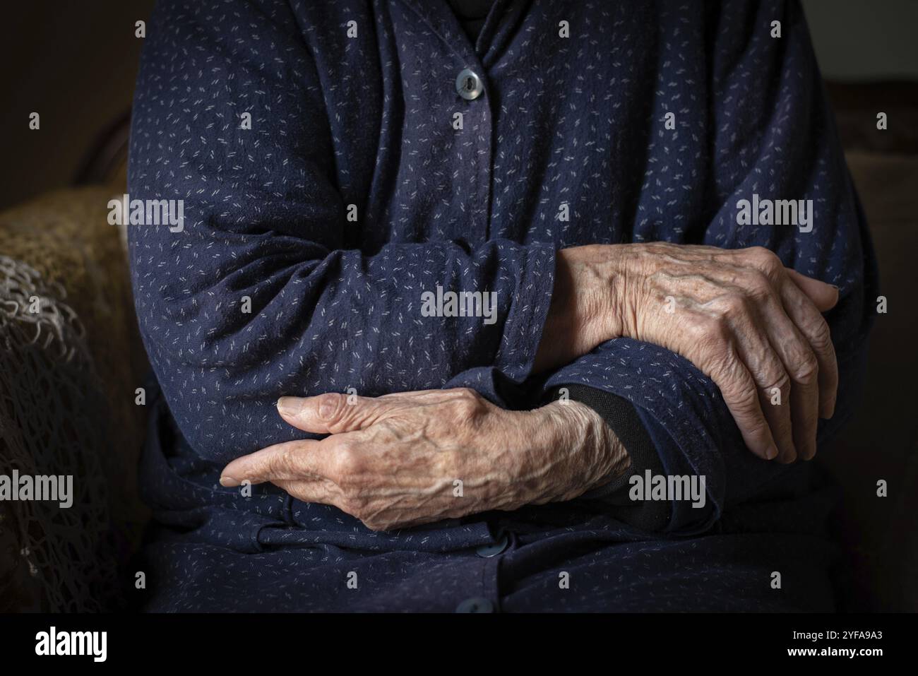 Femme aînée traversant ses belles mains ridées. Processus humain vieillissant Banque D'Images