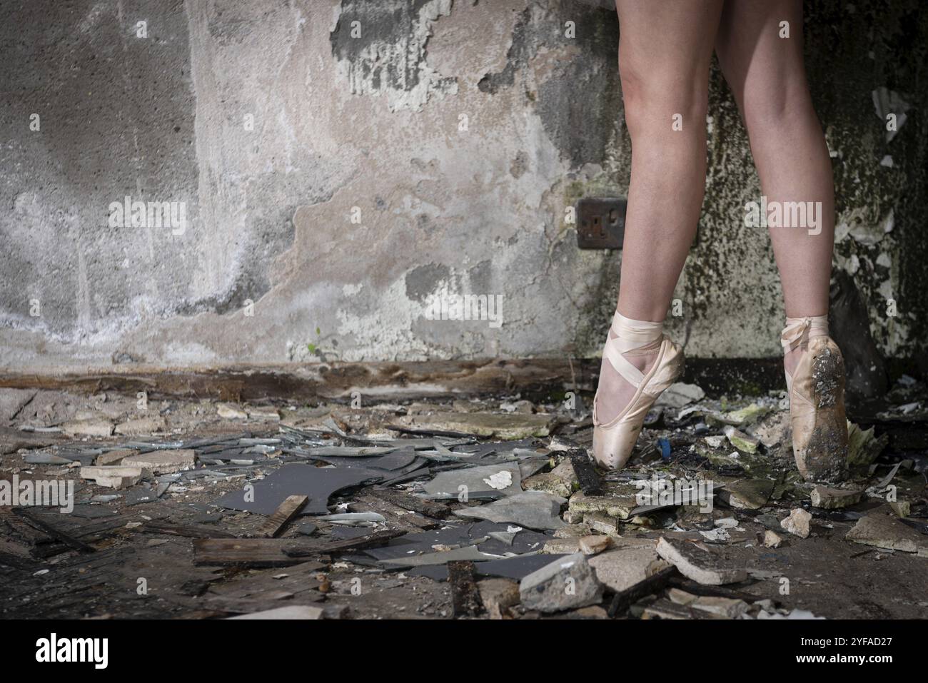 Gros plan des pieds de ballerine sur pointe dans des chaussures de ballet un lieu abandonné Banque D'Images