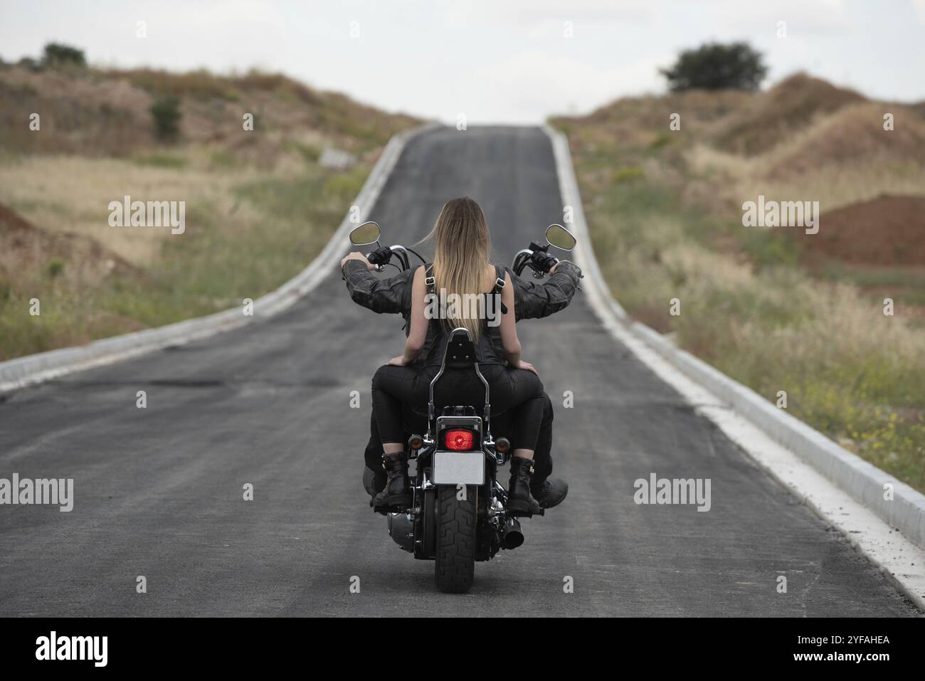 Sexy femme portant avec blonde cheveux longs équitation d'une moto de rue à l'extérieur. Exploration aventure voyage, vélo de rue Banque D'Images