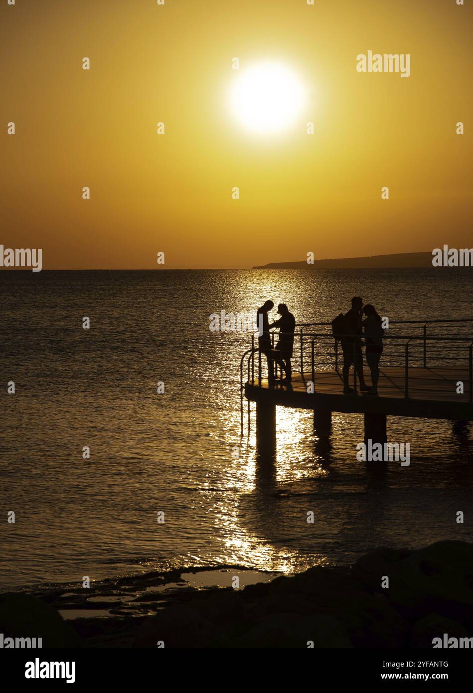 Silhouette de jeune couple profitant d'un beau coucher de soleil sur la plage. Moment romantique relation humaine à la terre Banque D'Images