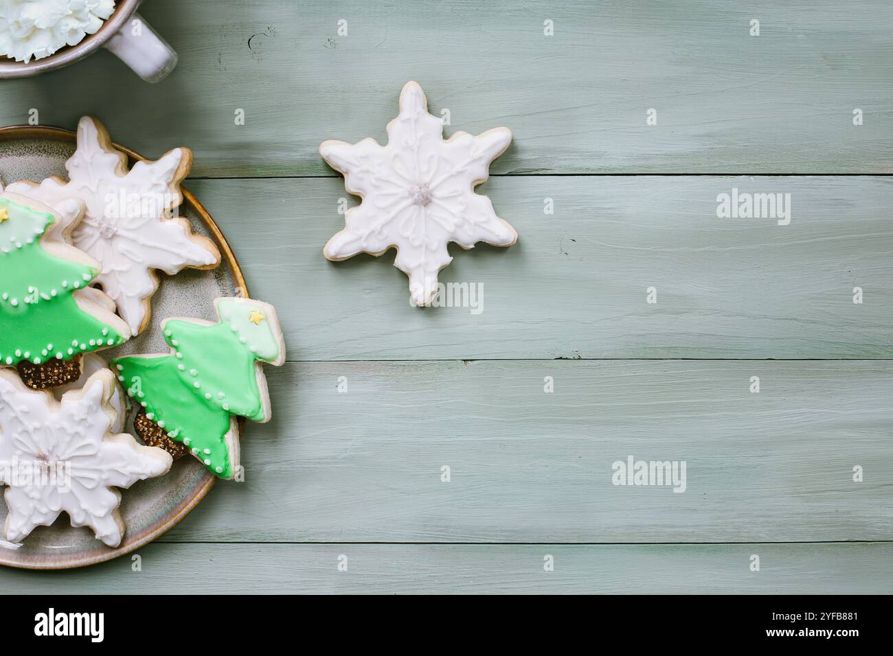 Flocon de neige givré de Noël et biscuits en forme d'arbre ou biscuits avec du vert avec glaçage blanc sur un fond rustique. Vue de dessus de table. Banque D'Images