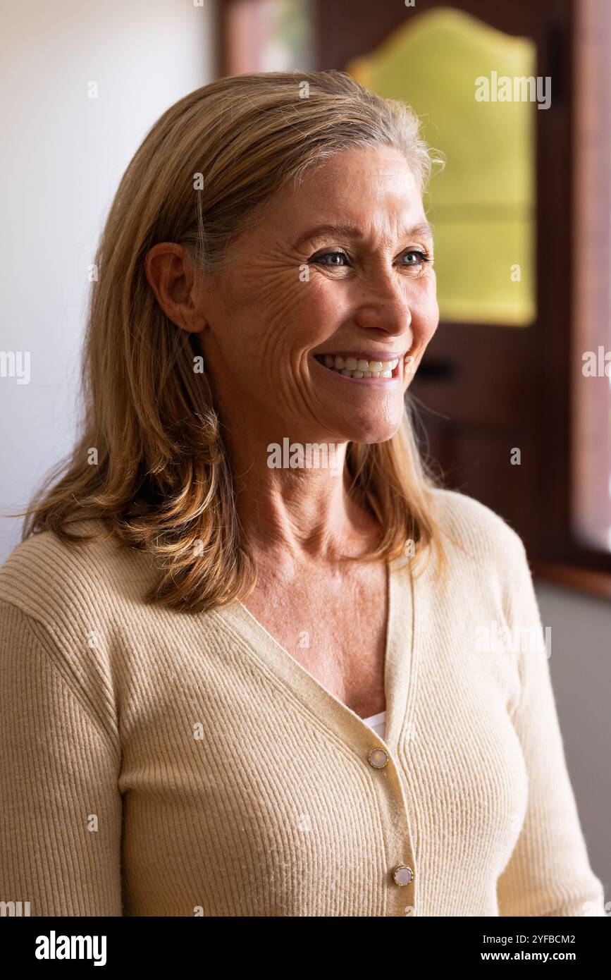 Femme âgée souriante profitant d'une atmosphère festive à la maison pendant Noël Banque D'Images