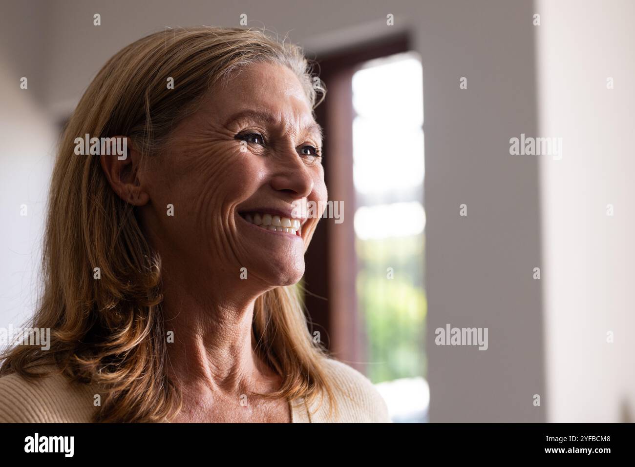 Porter une tenue de fête, femme senior décorant la maison avec des décorations de vacances Banque D'Images