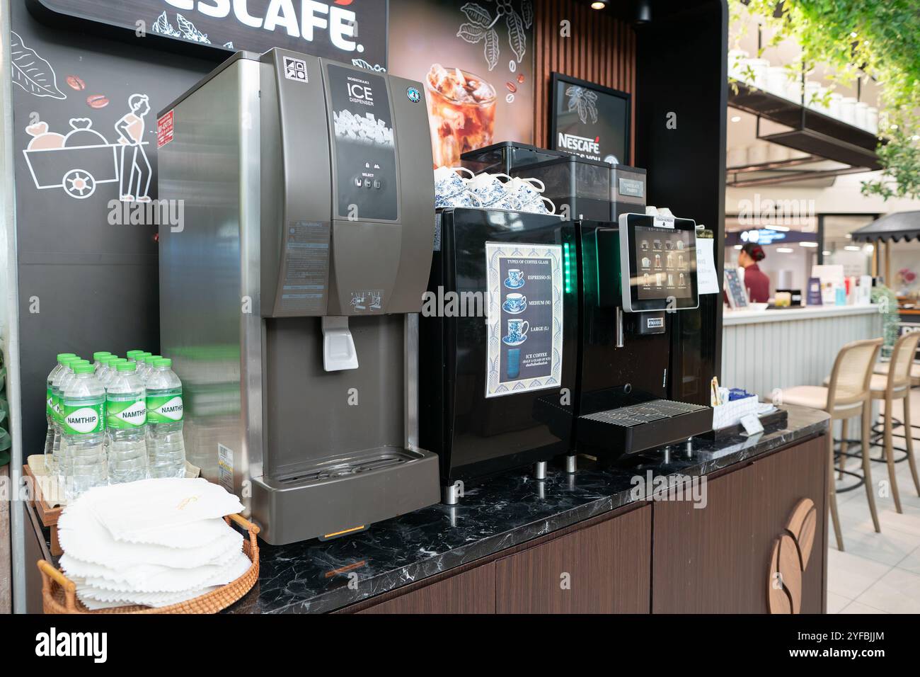 BANGKOK, THAÏLANDE - 26 OCTOBRE 2023 : distributeur de glaçons et machine à café au Coral Premium Lounge, aéroport national de Suvarnphumi. Banque D'Images