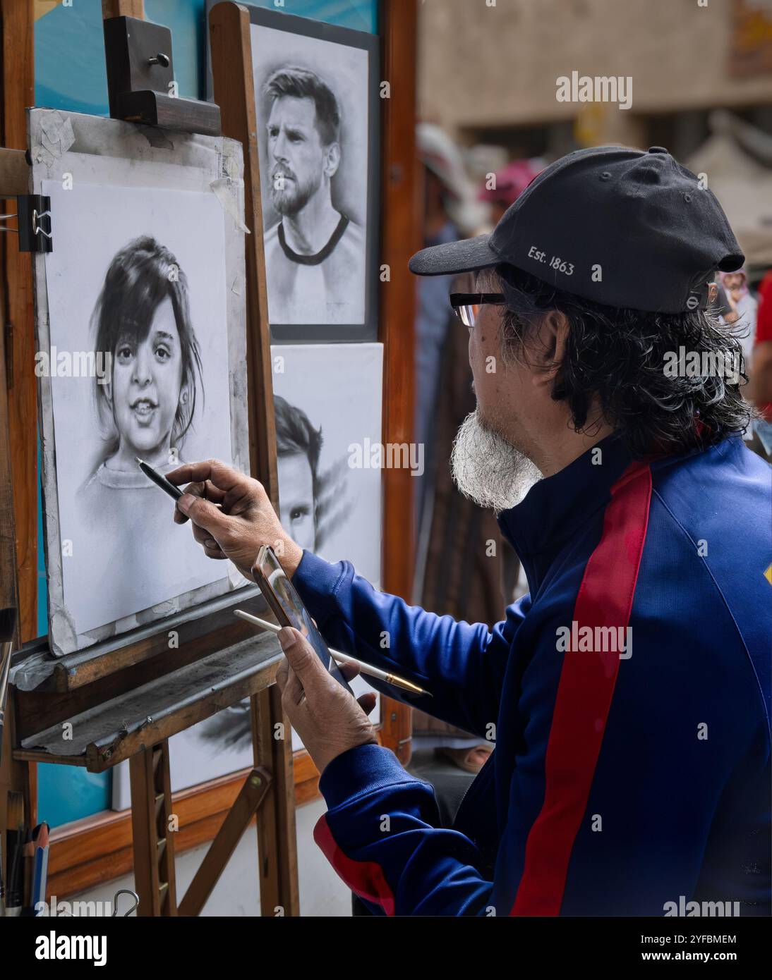 Cette scène captivante de la Coupe du monde de la FIFA au Qatar au Souq Waqif Fan zone montre un artiste dessinant avec passion des portraits, incarnant le f culturel Banque D'Images