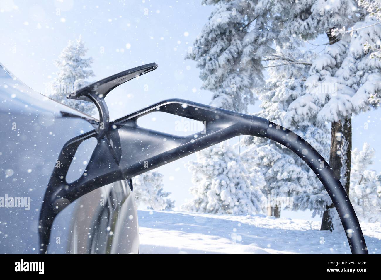 Gros plan de l'entrée de voiture électrique sur un fond de forêt d'hiver enneigée .. Banque D'Images