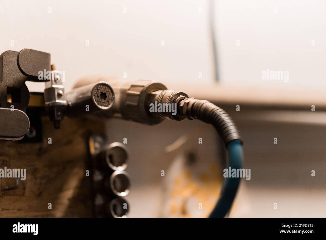 Gros plan détaillé d'un raccord de tuyau pneumatique monté dans un atelier. Banque D'Images